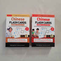 Two boxed Chinese Flash Cards learning kits by Tuttle, shown side by side on a light fabric background. The left box is Volume 1 with 360 flash cards, and the right box is Volume 2 with 720 characters, both with orange, white, and red packaging and photos of learners on the front.
