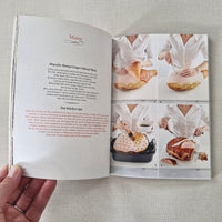 Open book with images of food and text on a textured surface
