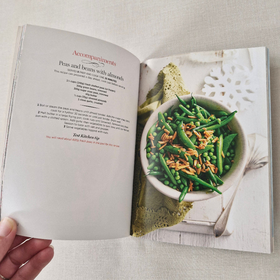 Open cookbook showing a page with a bowl of green beans and peas.