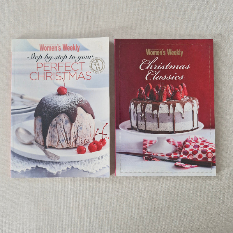 Two cookbooks on a textured surface, featuring Christmas-themed recipes.