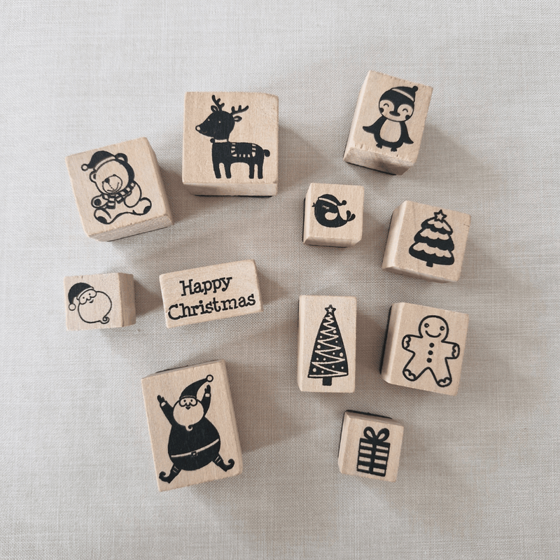 Set of Christmas-themed wooden stamps on a textured surface