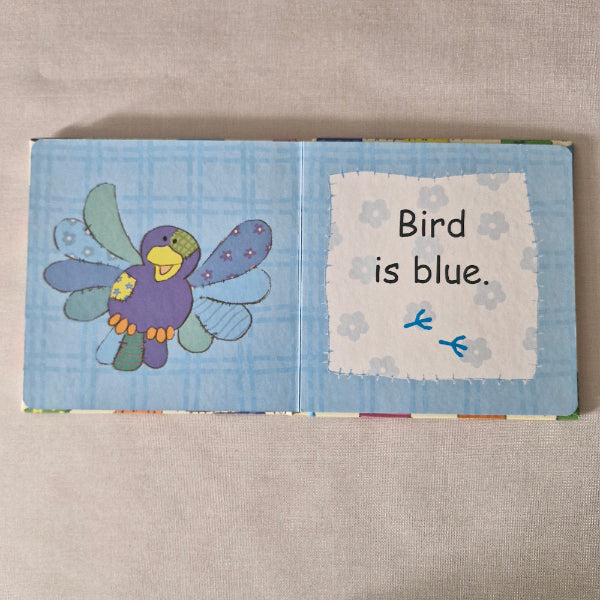 Children's book with a colourful bird illustration on a beige surface