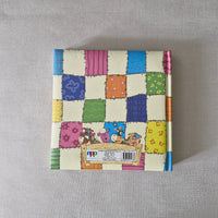 Colourful patchwork-style box with cartoon characters on a gray background