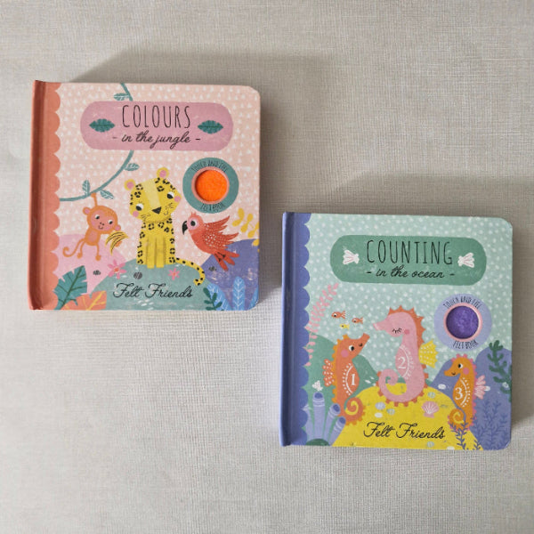 Two children's books titled 'Counting in the Ocean' and 'Colours in the Jungle' on a textured surface.