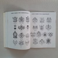 Open book with illustrations of coats of arms on a neutral background