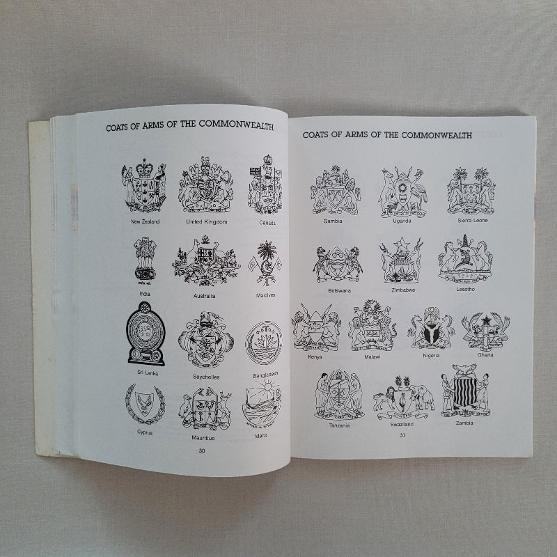 Open book with illustrations of coats of arms on a neutral background