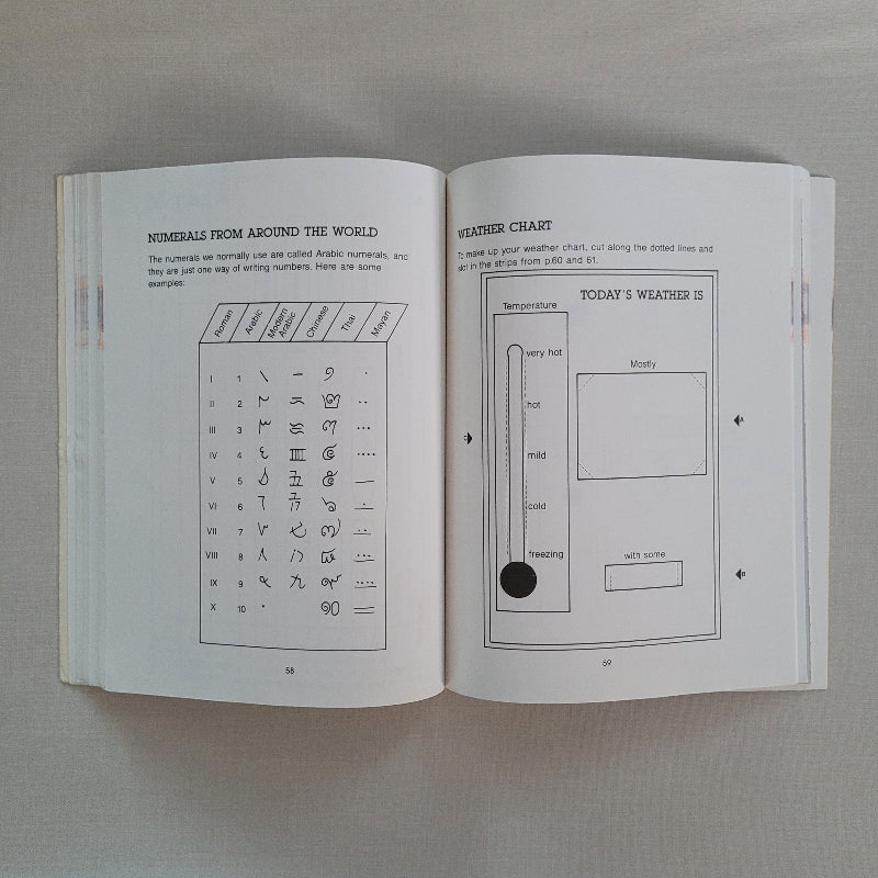 Open book with printed text and diagrams on a plain background