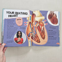 Book open to a page about the human heart with illustrations and text.