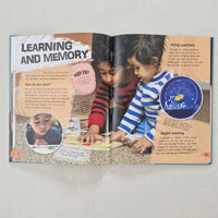 Open book with a collage of images about the human brain and text on a gray background