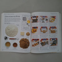 Open book with illustrations and text about cooking Gingerbread on a plain background