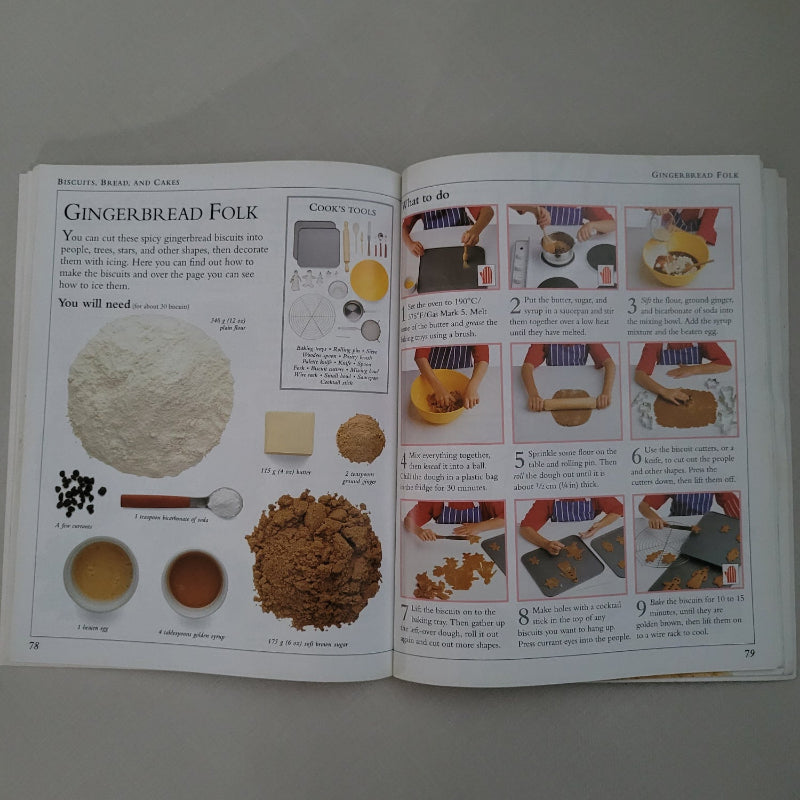 Open book with illustrations and text about cooking Gingerbread on a plain background