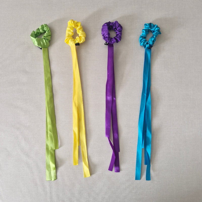 Four colourful bracelets with ribbons on a gray background