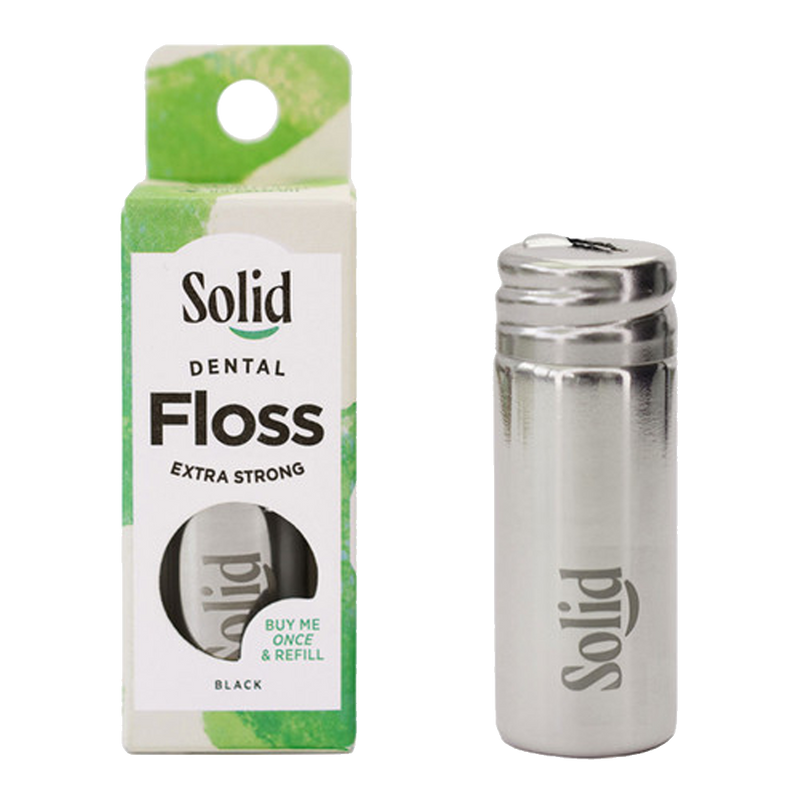 Solid dental floss packaging and stainless steel container on a white background
