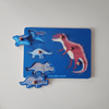 Wooden dinosaur puzzle with blue board and colorful dinosaur figures on a white background