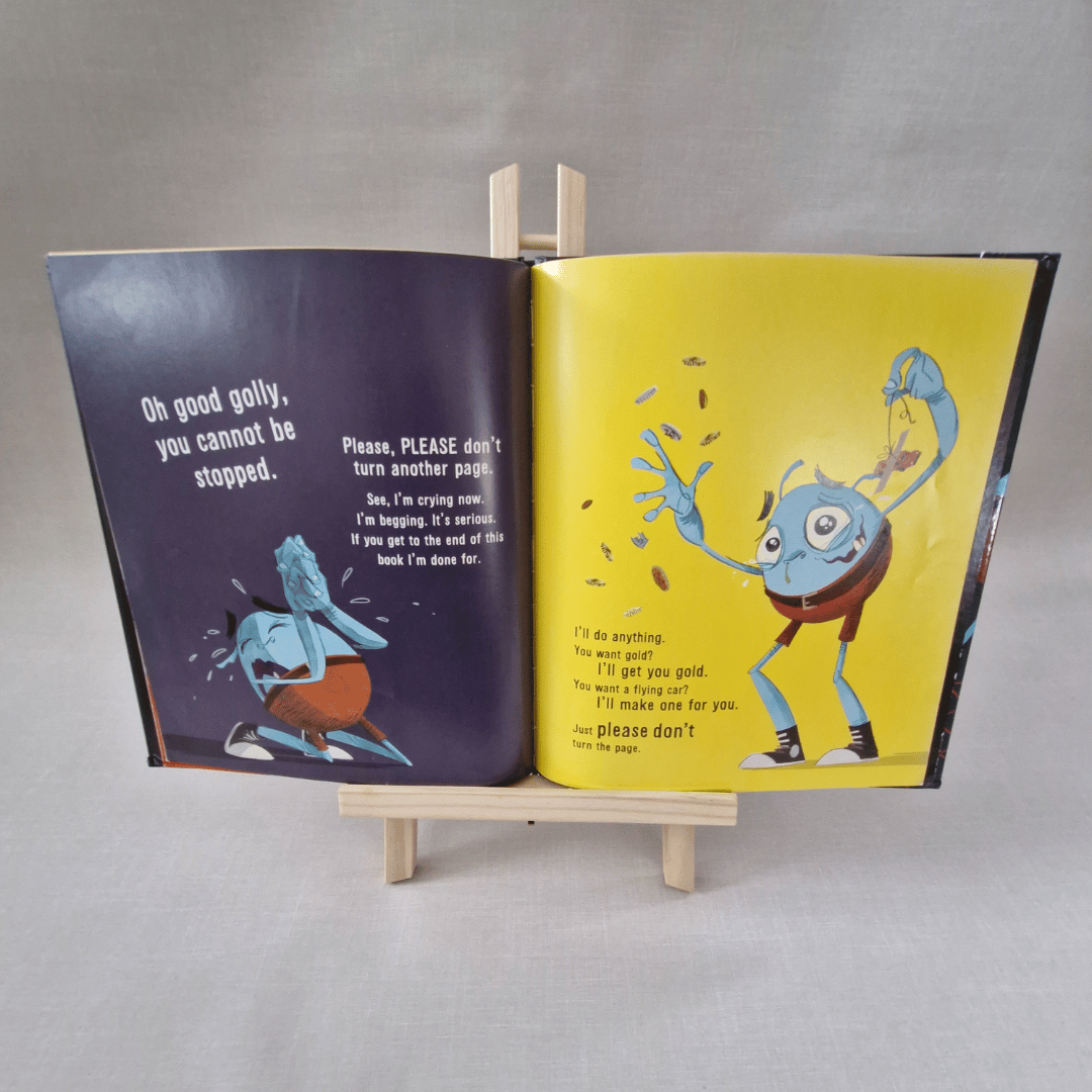 Open book with colourful illustrations of a blue creature on a grey background