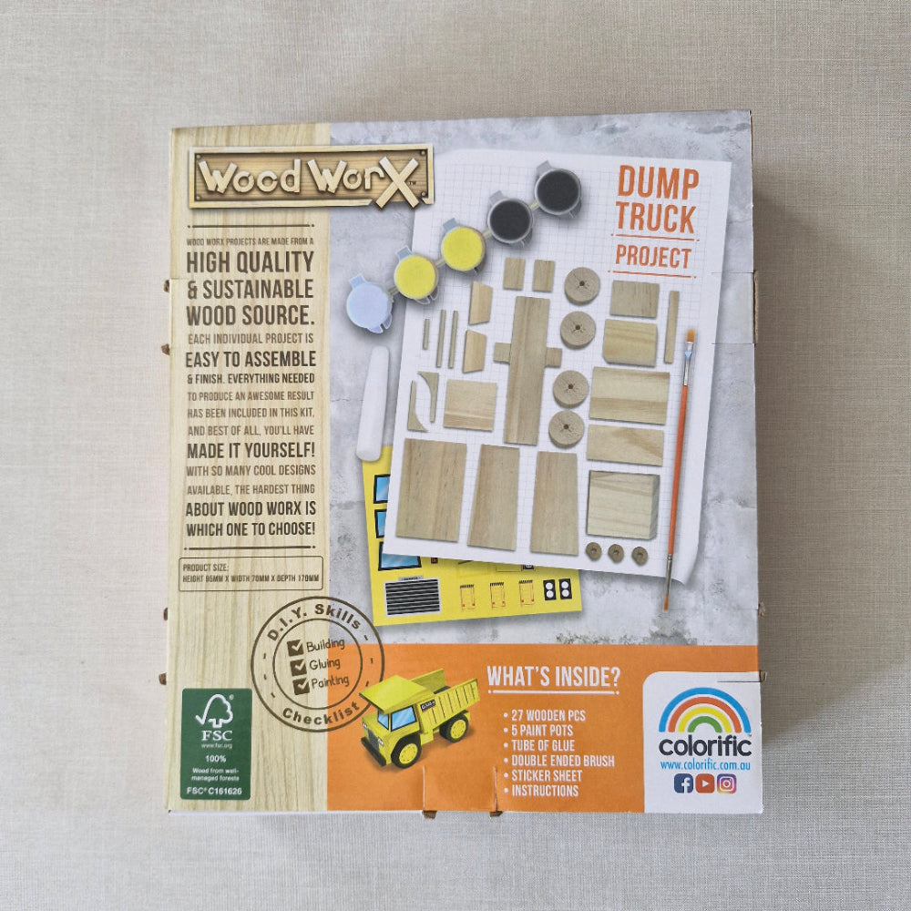 Woodworking kit packaging for a dump truck project on a grey surface