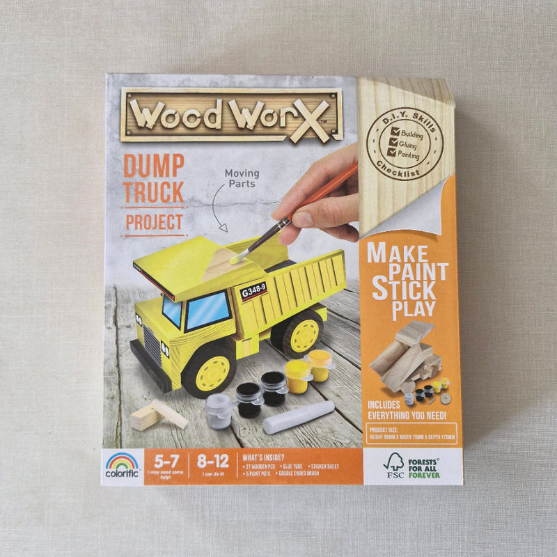 Wood craft kit packaging for a dump truck project on a textured surface
