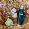 Blue Stanley thermos with two mugs on a patterned fabric background