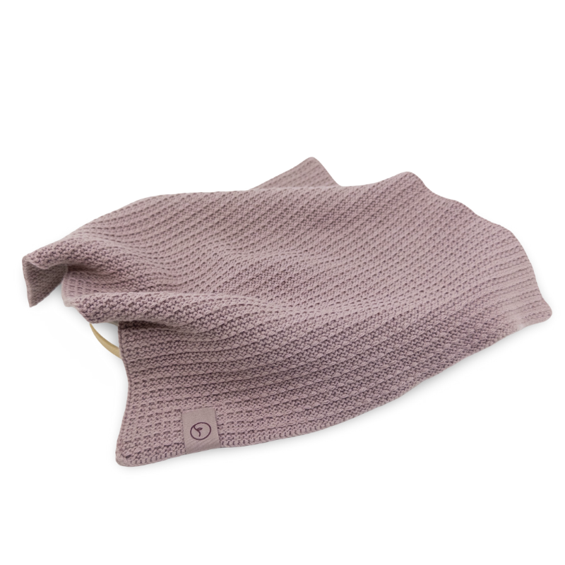 Folded Orchid pink knitted face cloth on a white background