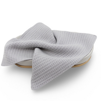 Gray knitted organic cotton face cloth on a white background 