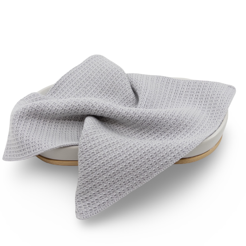 Gray knitted organic cotton face cloth on a white background 