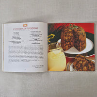 Open book with a Christmas pudding recipe on a textured surface