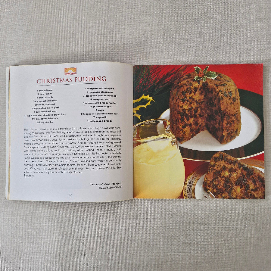 Open book with a Christmas pudding recipe on a textured surface