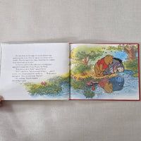 Open book showing a colourful illustration of Winnie the Pooh and Eeyore