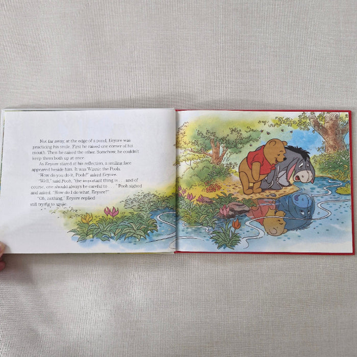 Open book showing a colourful illustration of Winnie the Pooh and Eeyore