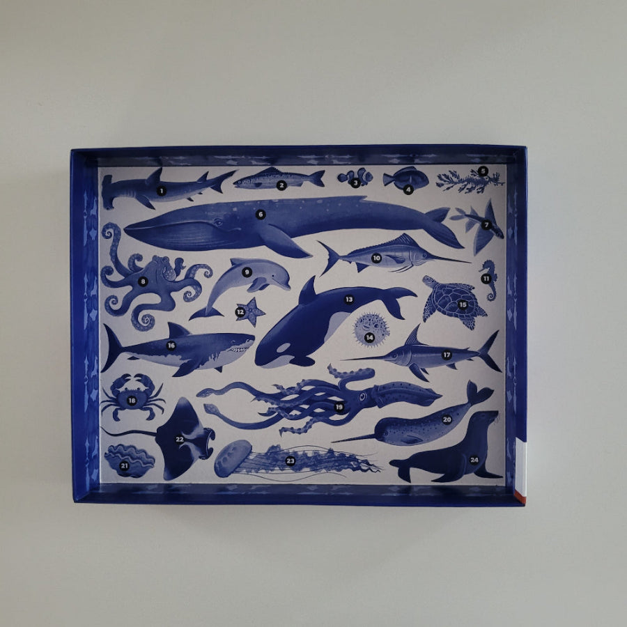Jigsaw box with blue ocean-themed illustrations on a white background