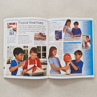 Open book with images of children playing and text on a beige surface