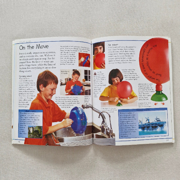 Open book with images of children playing with balloons on a beige surface