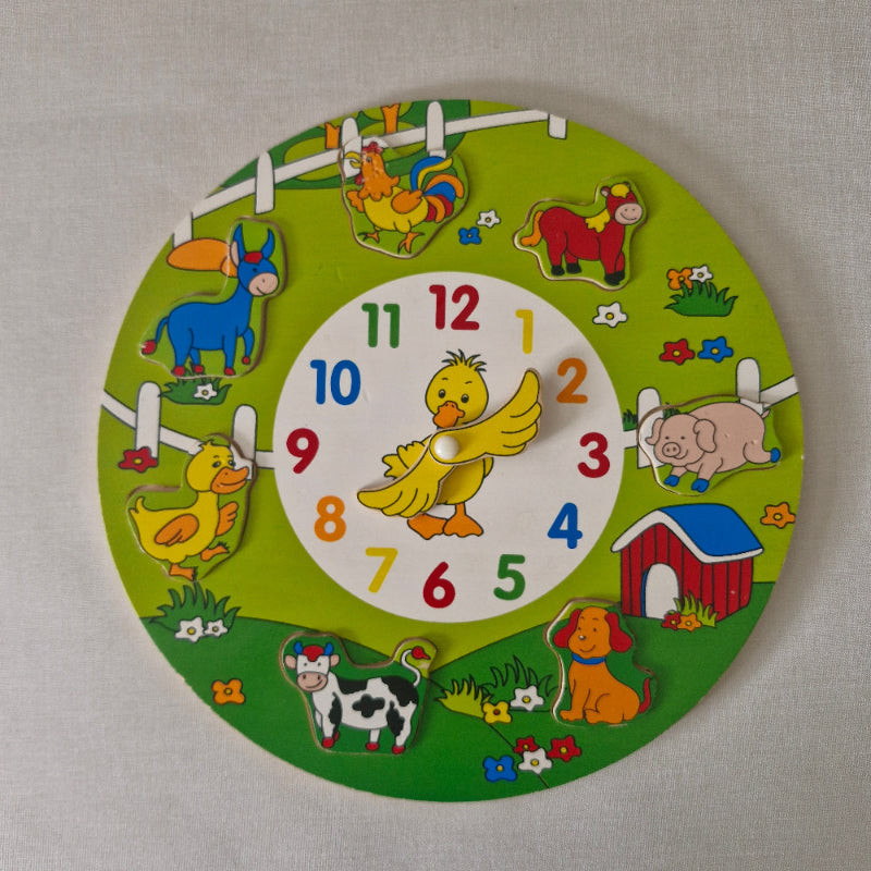 Children's clock with farm animal illustrations on a green background