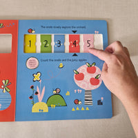 Children's book with interactive elements, including numbers tiles that slide across.
