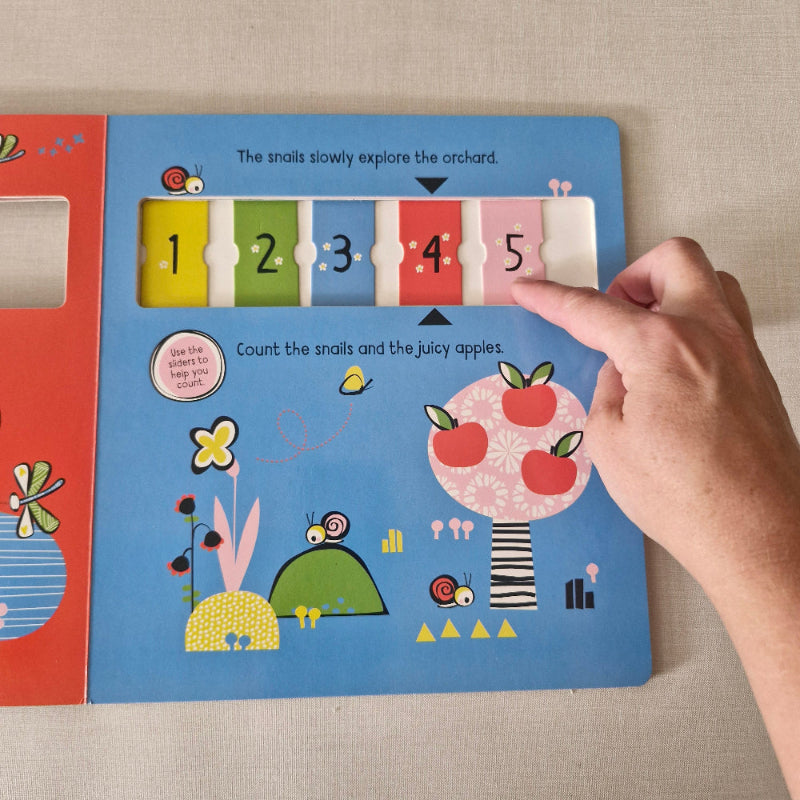 Children's book with interactive elements, including numbers tiles that slide across.