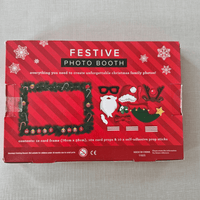 Red festive photo booth kit packaging on a grey surface