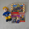 Fireman Sam toy figure with books and a puzzle on a gray surface
