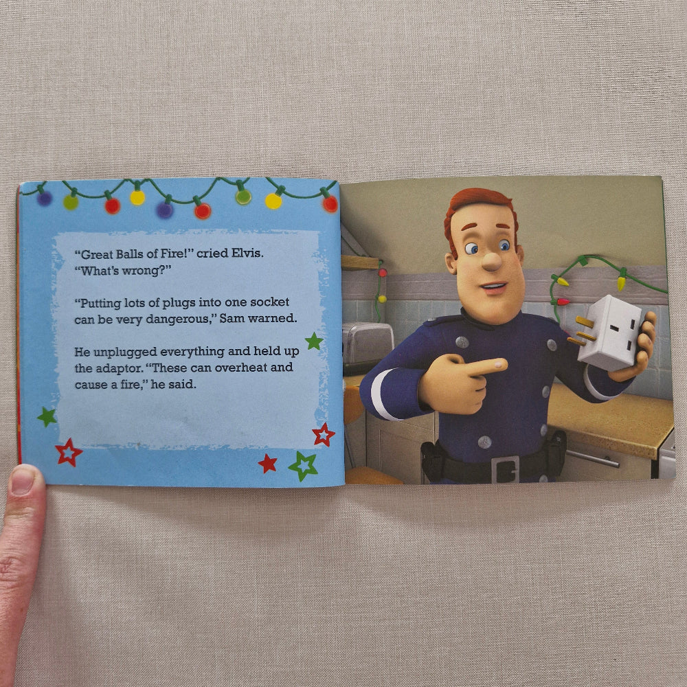 Open book showing fireman sam character and text on a beige surface