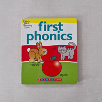 Children's book titled 'first phonics' with animal illustrations on a grey background