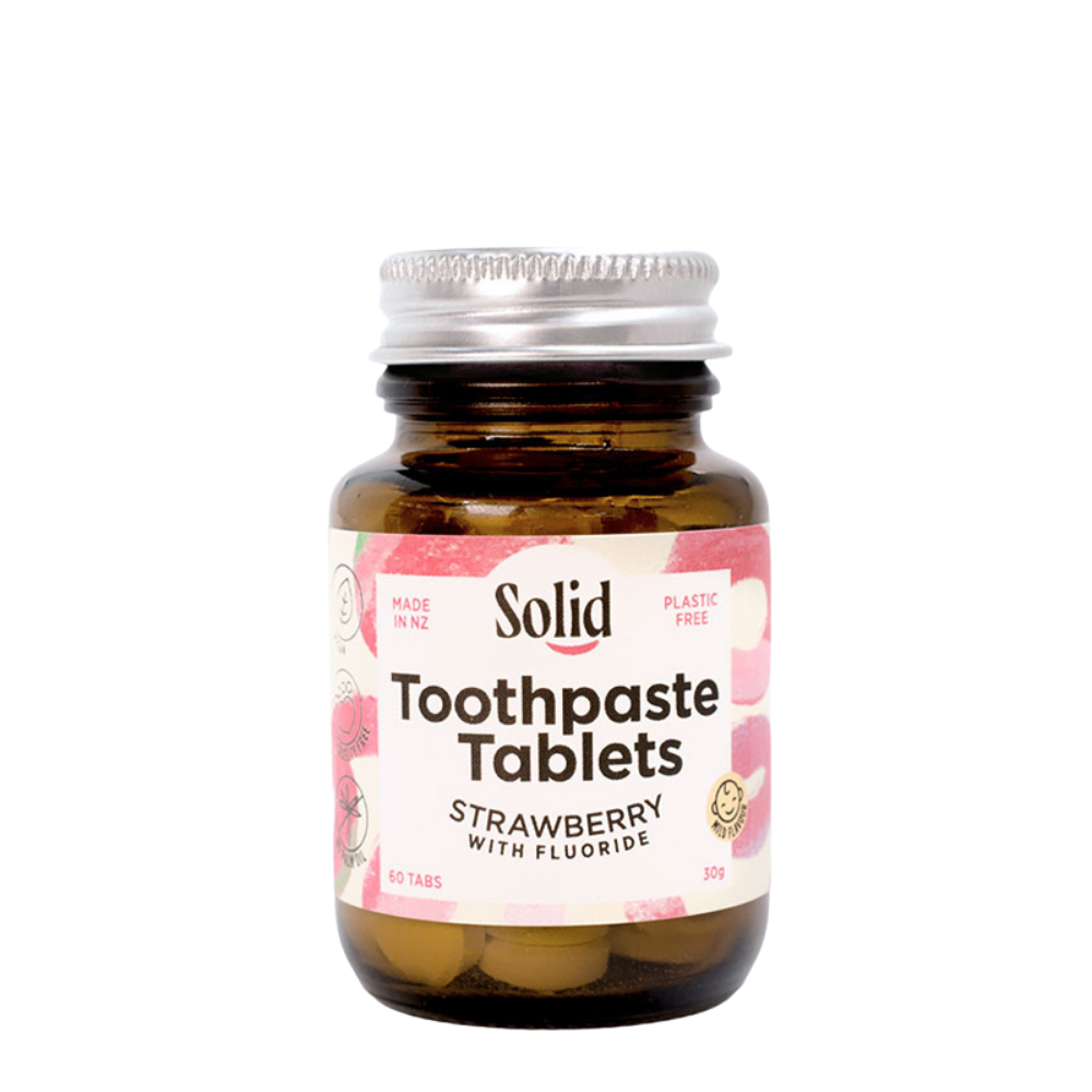 Bottle of Solid Toothpaste Tablets with strawberry flavor on a white background
