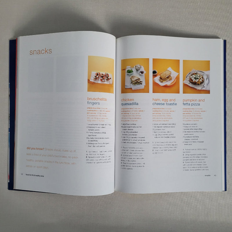 Open cookbook showing recipes with images of food on a neutral background