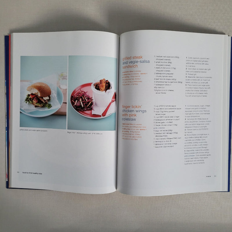 Open book with food images and text on a gray surface