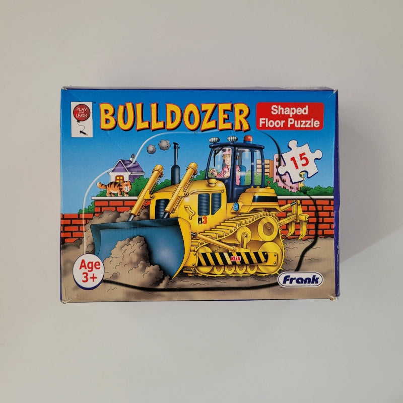 Box of a bulldozer-shaped floor puzzle for children on a plain background