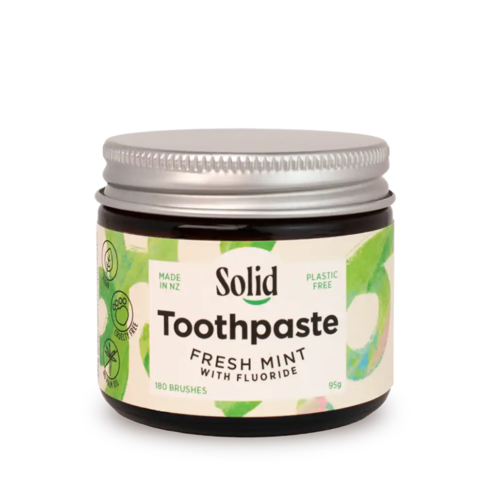Jar of solid toothpaste with a white background