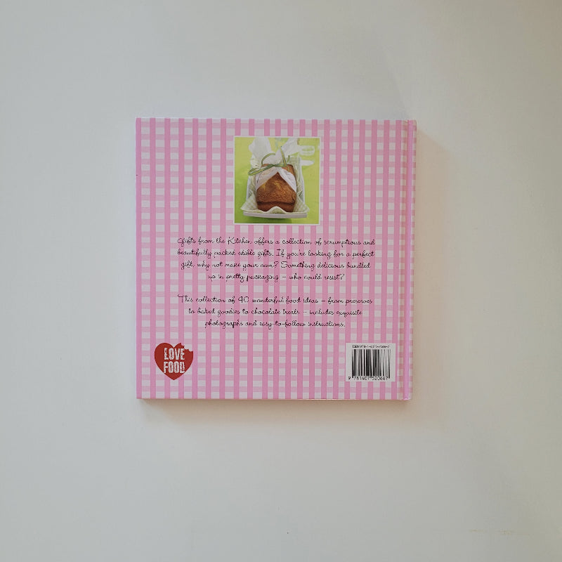 The back cover of a book with a pink and white gingham pattern, featuring a small photo of a heart-shaped sandwich, and handwritten text on a plain white background.