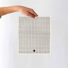 Person holding an eco cloth with grid pattern in front of white background
