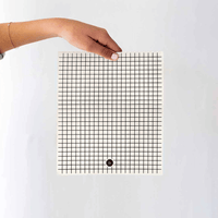 Person holding an eco cloth with grid pattern in front of white background