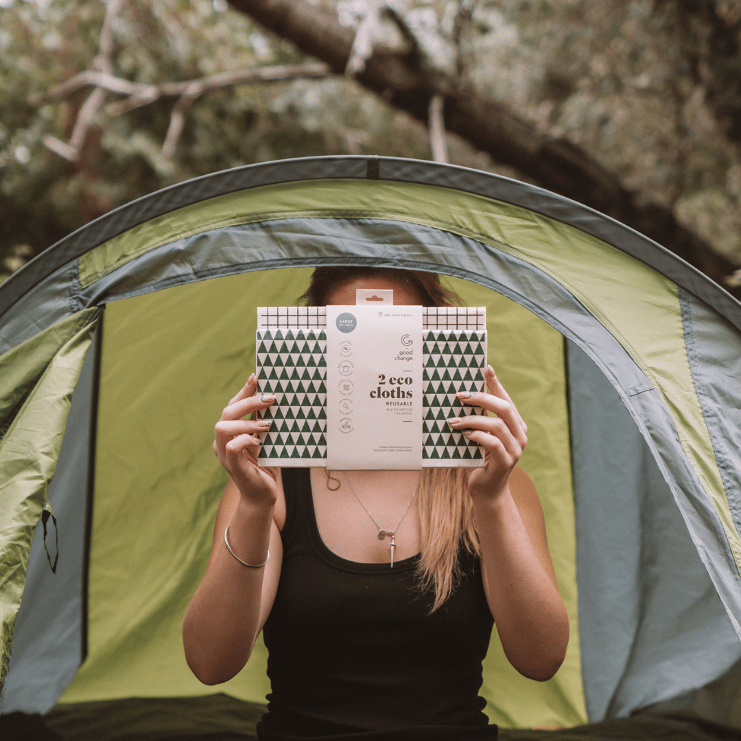 Person holding 2 pack of award winning large eco cloths from good change in front of their face inside a tent