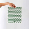Person holding a green and white geometric patterned eco cloth against a white background