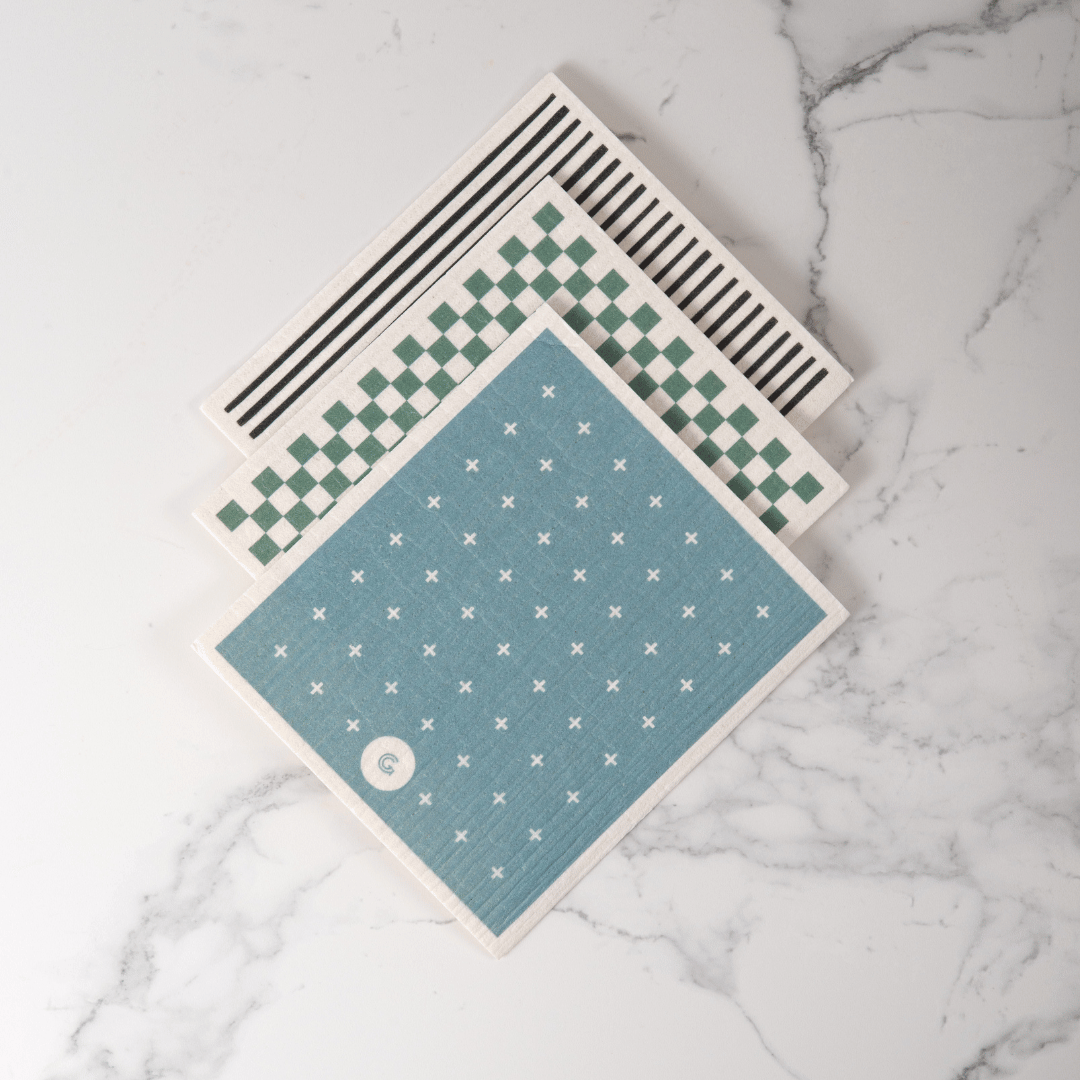 3 Pack of Good Change Eco Cloths, each with a different geometric pattern on a marble surface